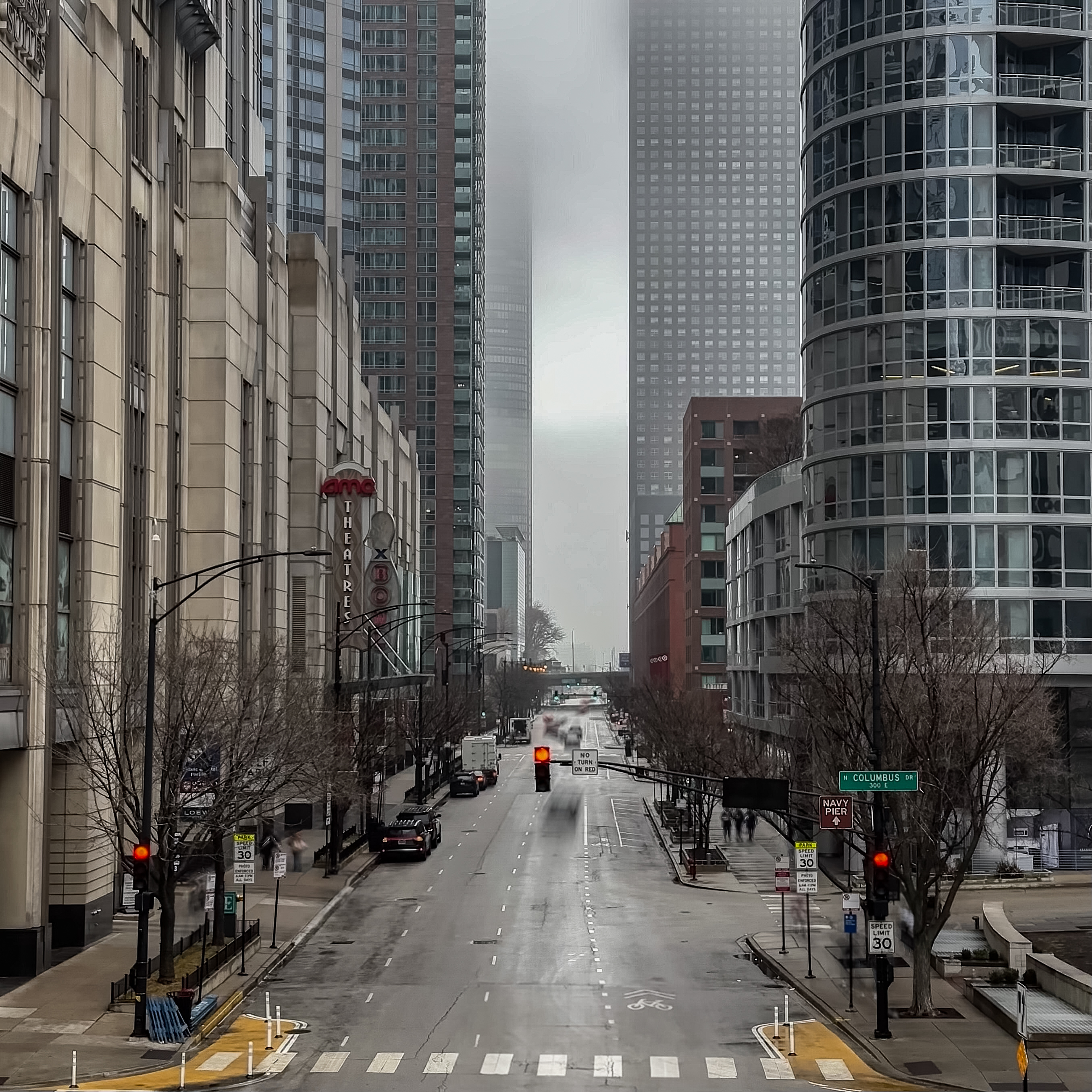 Downtown Chicago street lined with tall buildings on a foggy day